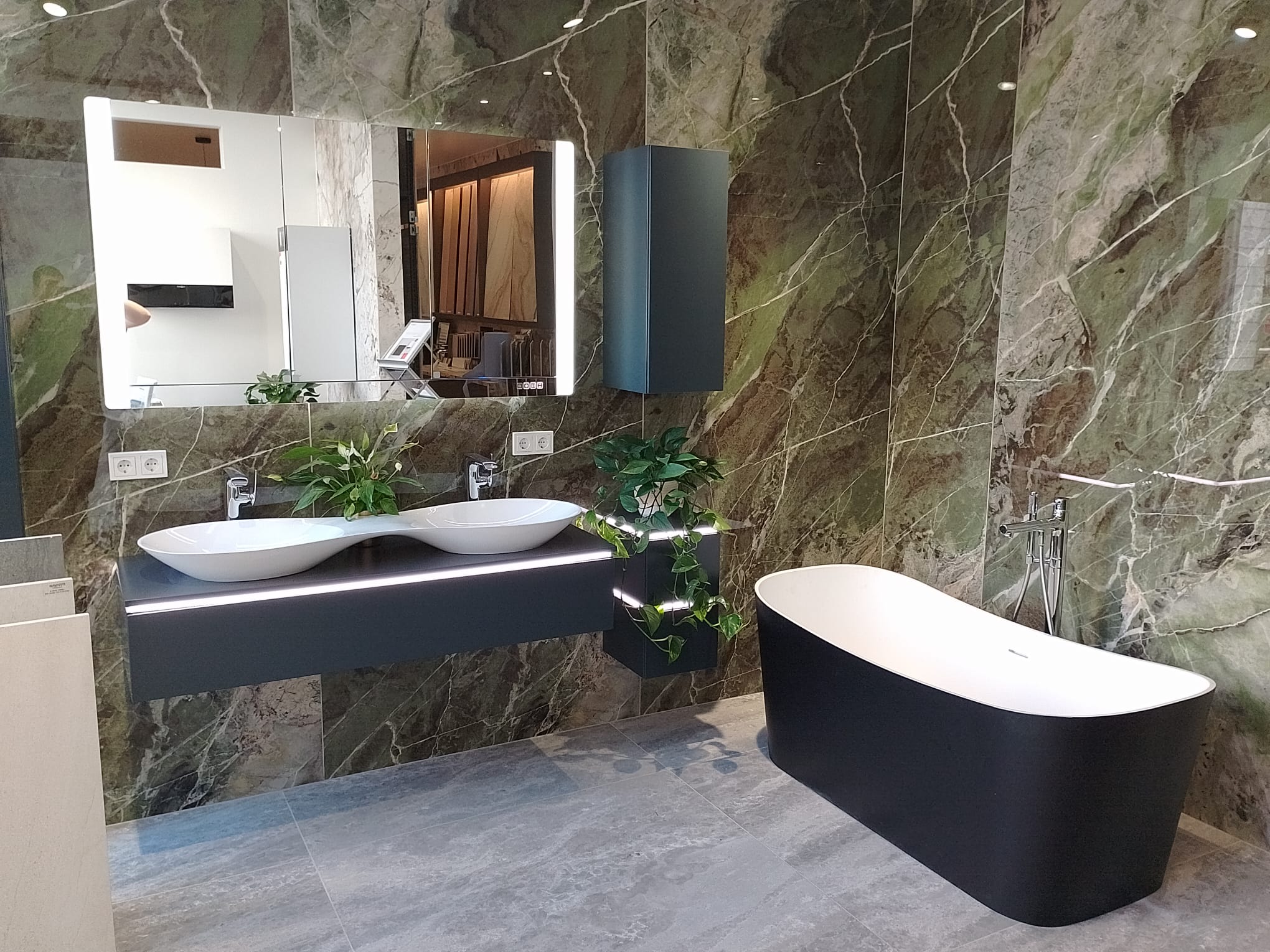 Salle de bains en marbre vert avec double vasque et baignoire îlot
